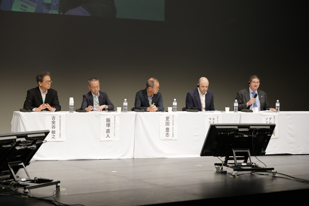 A group of professionals sitting at a panel at a forum in Japan