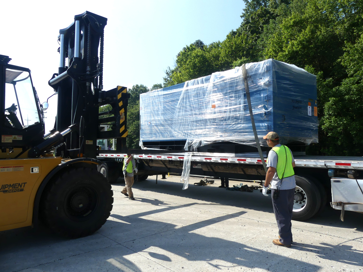 A large package on the back of a truck being lifted by a forklifted