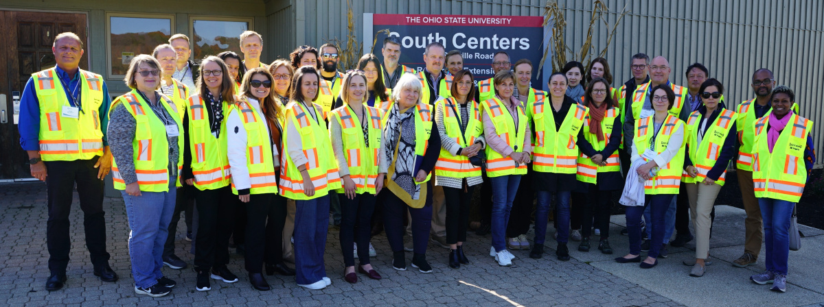 A large group of people in yellow safety vests posing for a picture
