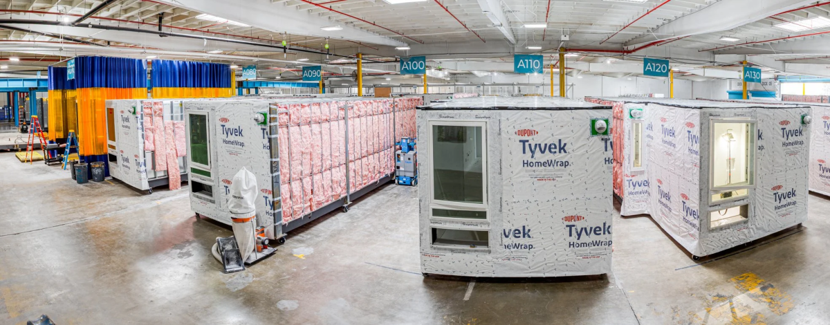 Large rows of wrapped housing materials in a warehouse.