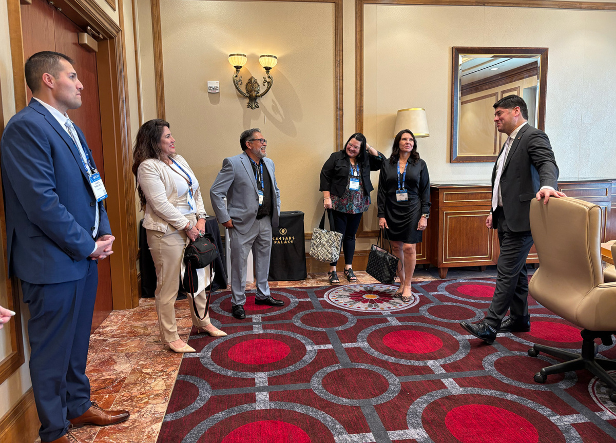 Six people standing and speaking to one another