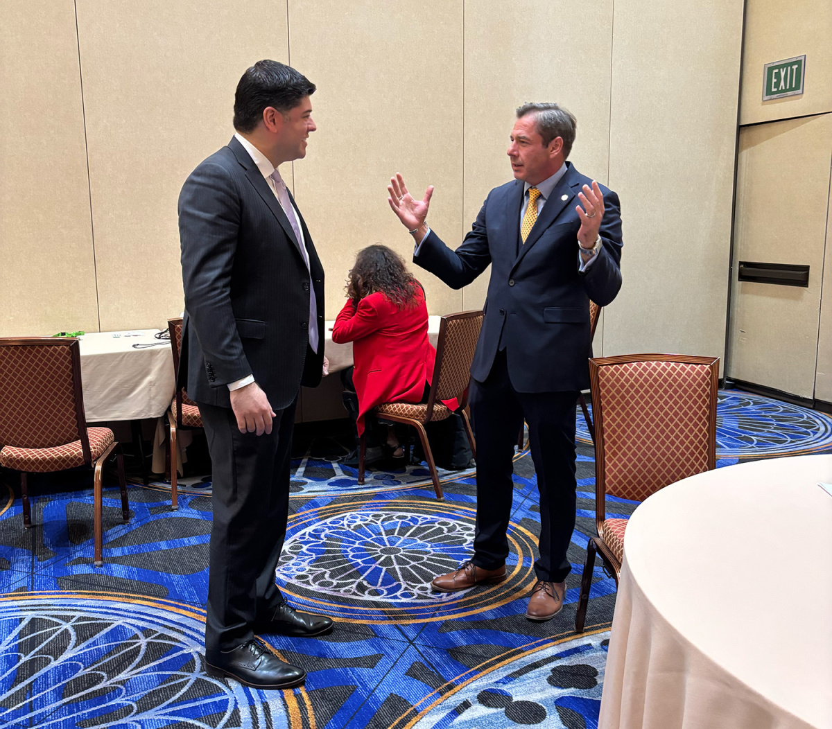 Two people standing and speaking to one another