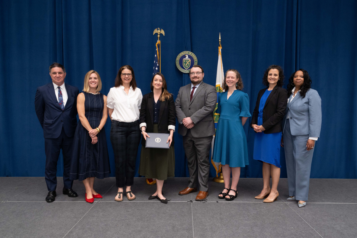 A group of people posing for an image holding an awards plaque.