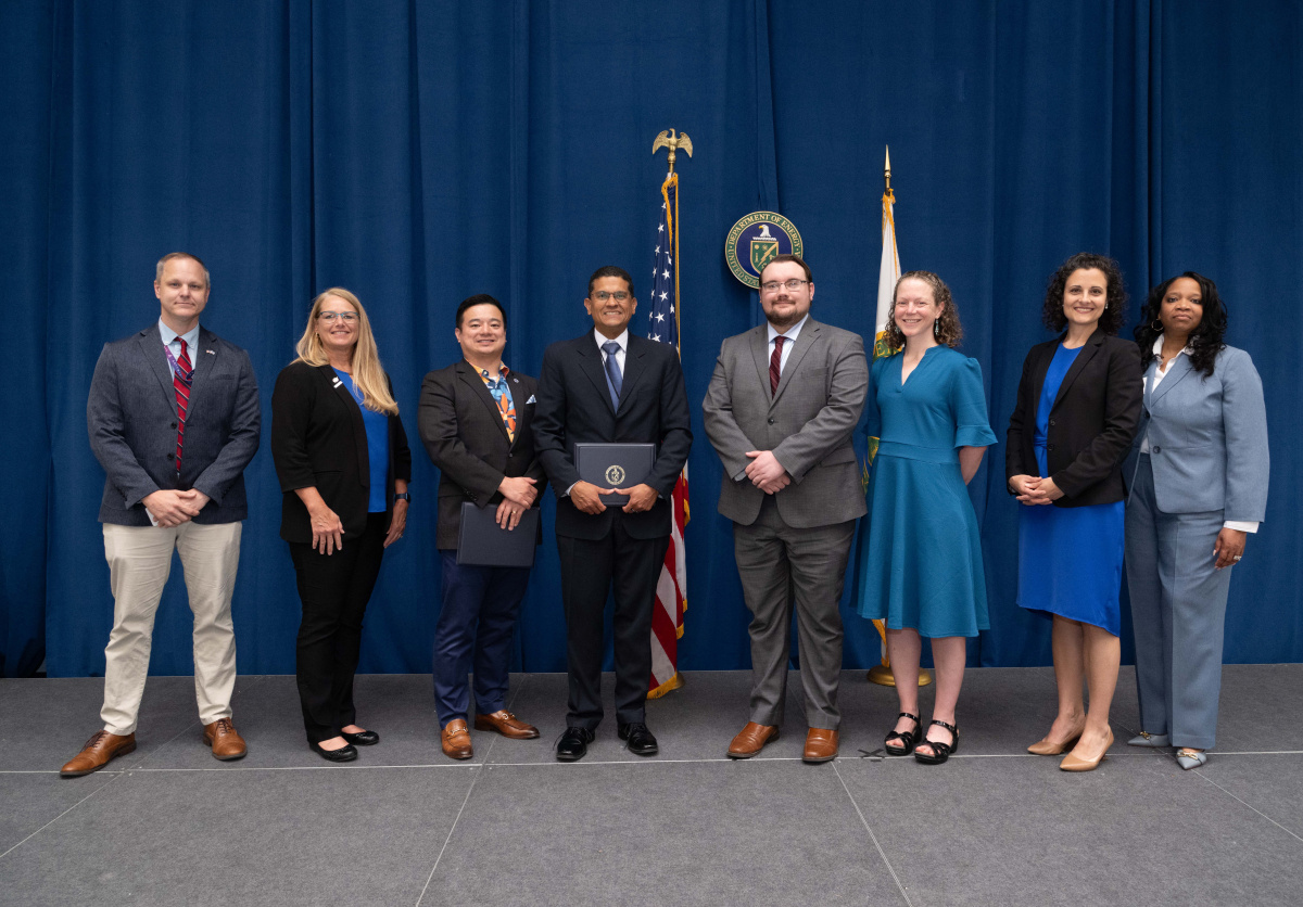 A group of people posing for an image holding an awards plaque.