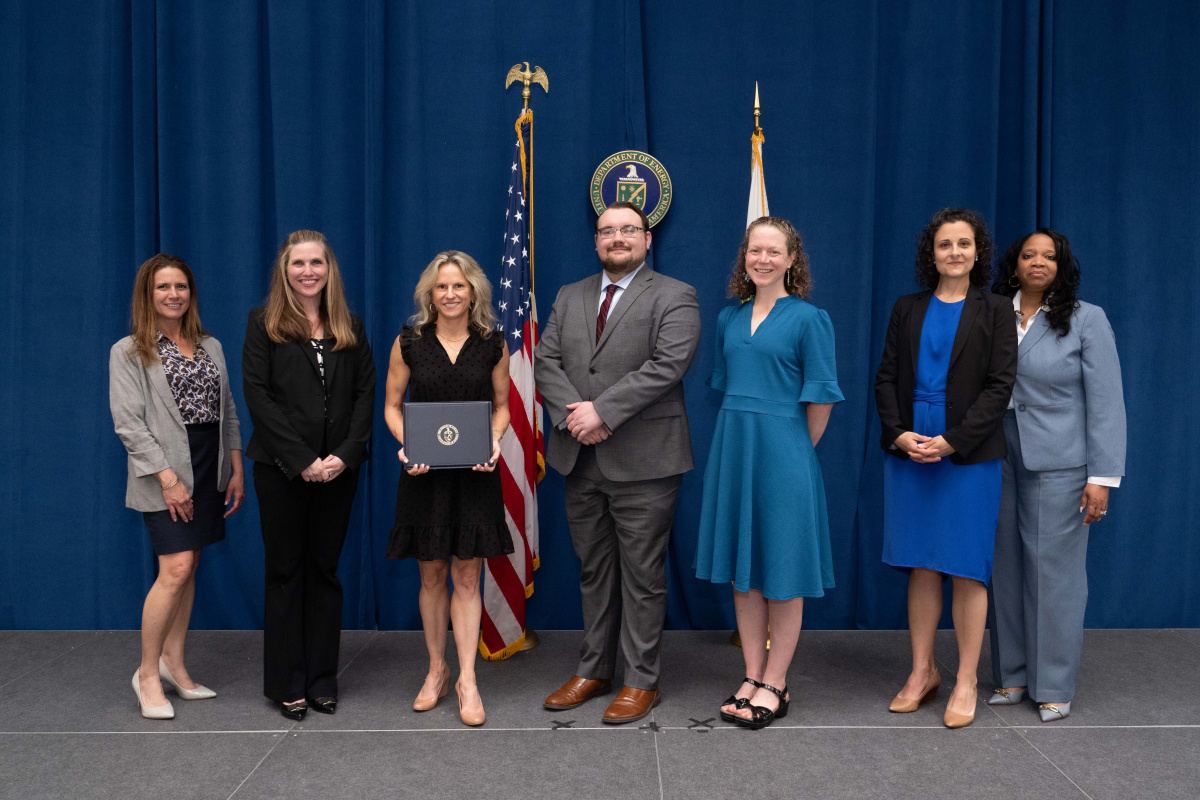 A group of people posing for a photo holding an awards plaque.
