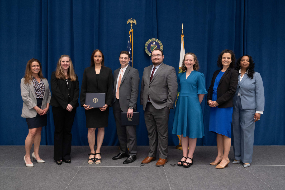 A group of people posing for a photo holding an awards plaque.