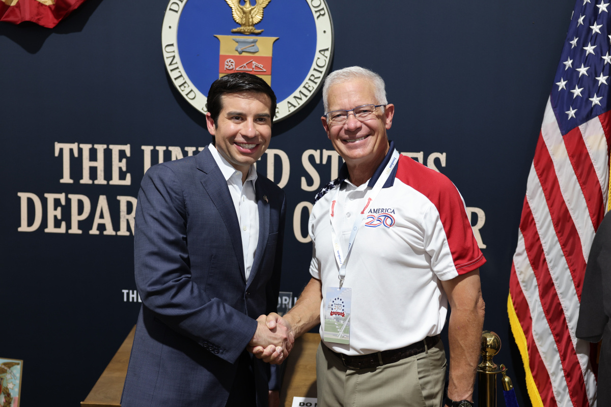 Two men shaking hands at the joint fair booth