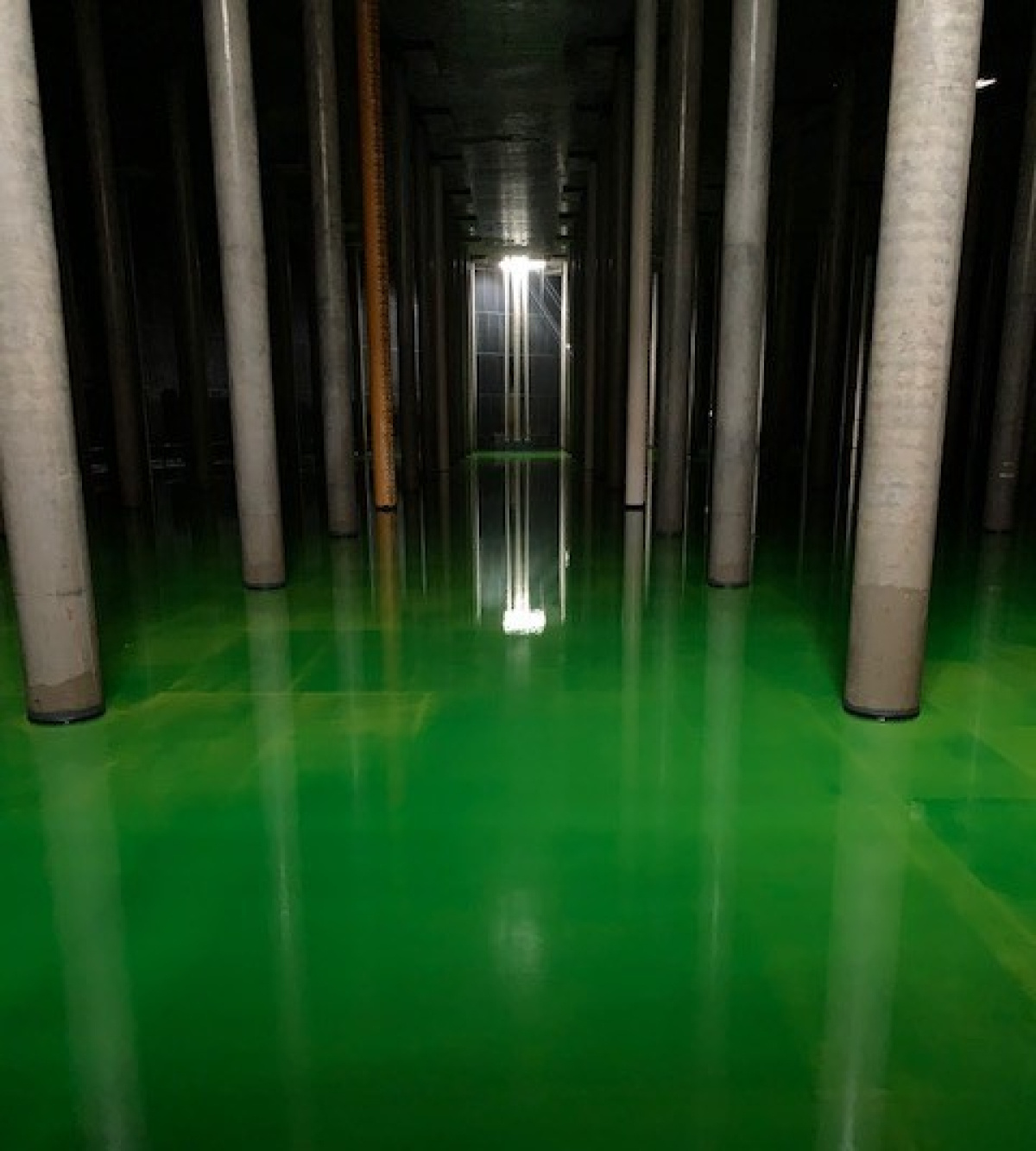 A leak test occurring inside a large disposal unit building