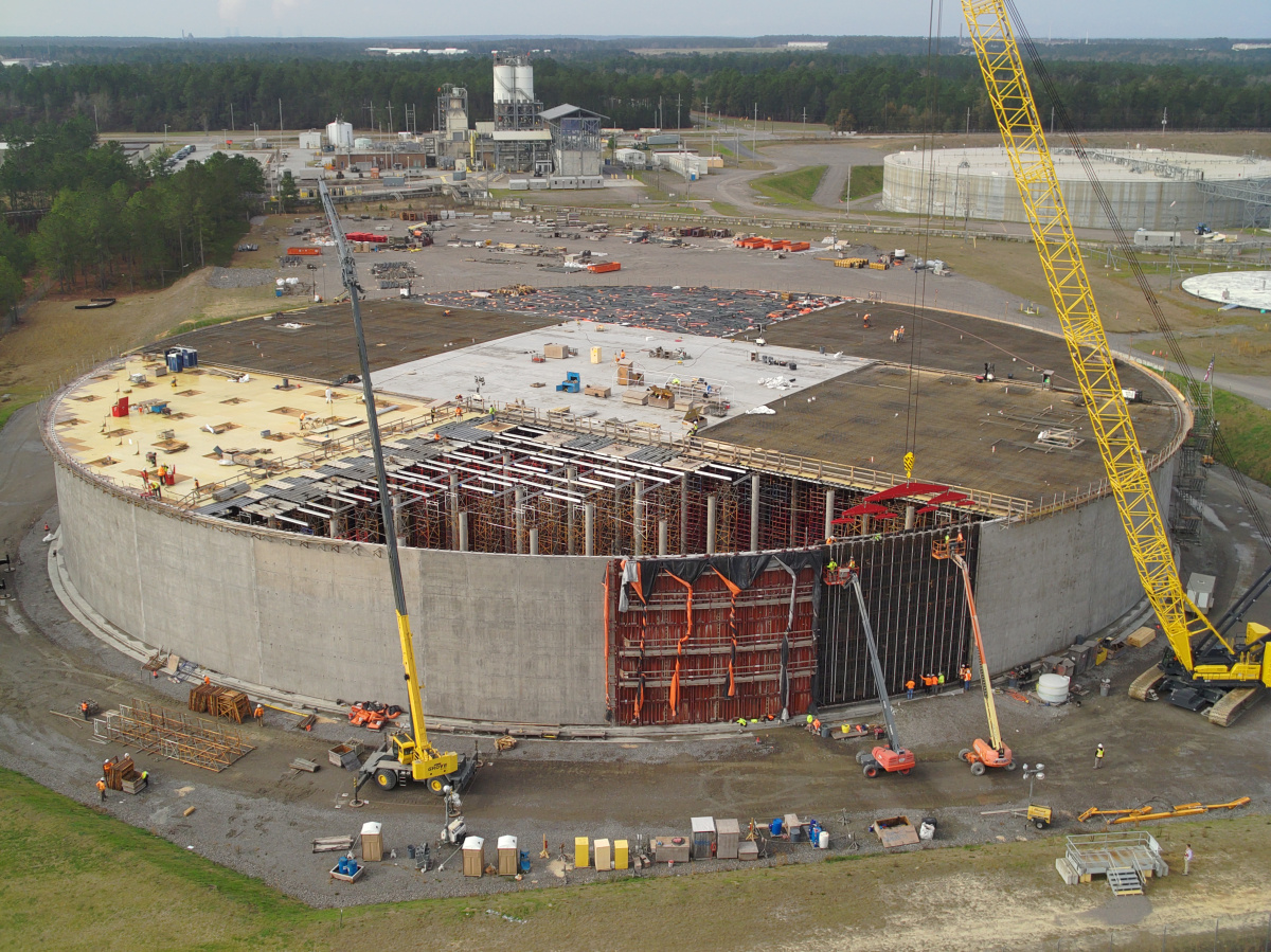 Aerial view of a roof being placed on a large circular building at SRS