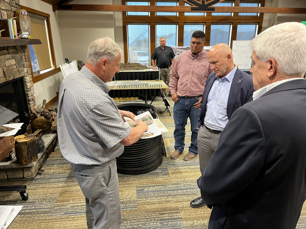 A photo of individuals standing around a room speaking with each other