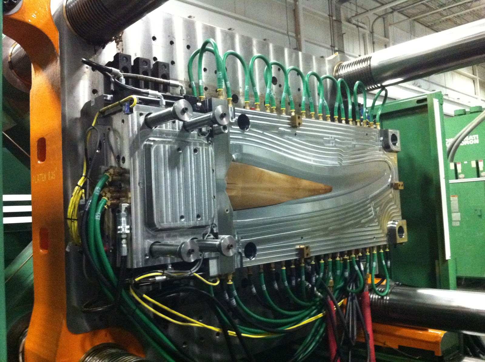 Pika Energy’s injection-molding tool for manufacturing wind turbine blades. <em>Photo by Pika Energy, NREL 33941</em> A photo of a large machine with many wires and tubes sticking out of it.