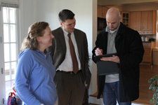 Now that they understand the process and the value of completing home energy efficiency upgrades, more GCEA customers are completing upgrades. A photo of three people standing and talking to each other, two men and a woman, inside a home.