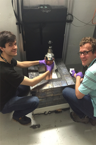 Bjorn Scholz (left) from the University of Chicago and Grayson Rich of the University of North Carolina at Chapel Hill and the Triangle Universities Nuclear Laboratory show off the world's smallest neutrino detector, which is part of the COHERENT experiment.