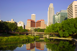 Omaha, Nebraska Photo of tall buildings in a city skyline, with a river spread out in the foreground.