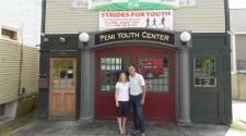 Executive Director Jessica Dutille stands outside the Pemi Youth Center with Mike Turcotte of Turn Cycle Solutions, who installed upgrades to the center. Photo of a man and woman standing outside the front entrance of the Perni Youth Center.