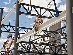 Photo of NREL's Research Support Facility under construction, with two workers straddling I-beams.