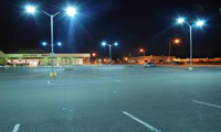 Photo of an outdoor supermarket parking lot with four LED light poles in view.