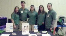 Photo of a group of five people standing, looking at the camera.