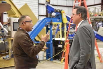 Idaho National Laboratory (INL) Director Mark Peters (right) talks with INL researcher Jaya Tumuluru, whose DOE Lab-Corps project is a high moisture pelleting process for the raw biomass material that feeds biofuel refineries. Image: Idaho National Laboratory. Idaho National Laboratory (INL) Director Mark Peters (right) talks with INL researcher Jaya Tumuluru, whose DOE Lab-Corps project is a high moisture pelleting process for the raw biomass material that feeds biofuel refineries. Image: Idaho National Laboratory.