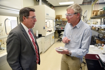 Idaho National Laboratory (INL) Director Mark Peters talks with INL research lead Tedd Lister whose Lab-Corps project is working to retrieve critical and rare earth materials from devices such as computers and cell phones. Image: Idaho National Laboratory. Idaho National Laboratory (INL) Director Mark Peters talks with INL research lead Tedd Lister whose Lab-Corps project is working to retrieve critical and rare earth materials from devices such as computers and cell phones. Image: Idaho National Laboratory.
