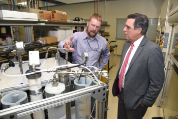 Idaho National Laboratory (INL) Director Mark Peters (right) talks with INL researcher Aaron Wilson, whose DOE Lab-Corps project is a water treatment process with the potential to cost-effectively recover clean water from dirty, salty, industrial wastewater. Image: Idaho National Laboratory. Idaho National Laboratory (INL) Director Mark Peters (right) talks with INL researcher Aaron Wilson, whose DOE Lab-Corps project is a water treatment process with the potential to cost-effectively recover clean water from dirty, salty, industrial wastewater. Image: Idaho National Laboratory.
