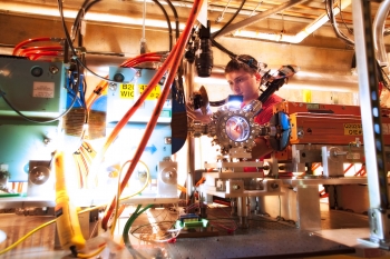 At the SLAC National Accelerator Laboratory, scientists are using the Facility for Advanced Accelerator Experimental Tests, also known as FACET, to research accelerator science and high-energy density physics.  SLAC's particle accelerator may be two miles long, but researchers at FACET are working to develop more compact versions that could be widely used in medicine and industry -- particle accelerators are used for cancer research, processing computer chips, and even producing the shrink wrap used to keep your Thanksgiving turkey fresh. In this photo, Stanford graduate student Spencer Gessner assembles a camera that will monitor an X-ray spectrometer designed to measure FACET's beam energy. Learn more about <a href="http://youtu.be/IA5pksr_gfY">how FACET works</a>. | Photo courtesy of SLAC National Accelerator Laboratory.