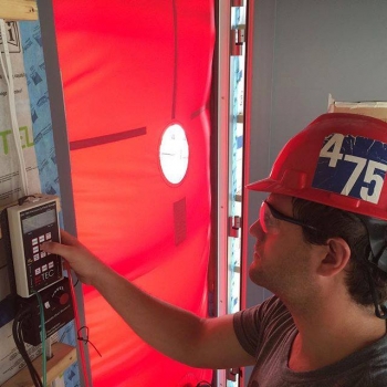 Stevens Institute of Technology checks the air-tightness of its SURE HOUSE with a blower door test. | Photo courtesy of Stevens Institute of Technology. Stevens Institute of Technology checks the air-tightness of its SURE HOUSE with a blower door test. | Photo courtesy of Stevens Institute of Technology.
