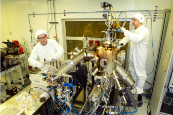 Inside a clean room, Brookhaven physicists Ivan Bozovic (left) and Anthony Bollinger work on the molecular beam epitaxy system that produced the atomically perfect materials used in the study. | Photo courtesy of Brookhaven National Lab Inside a clean room, Brookhaven physicists Ivan Bozovic (left) and Anthony Bollinger work on the molecular beam epitaxy system that produced the atomically perfect materials used in the study. | Photo courtesy of Brookhaven National Lab