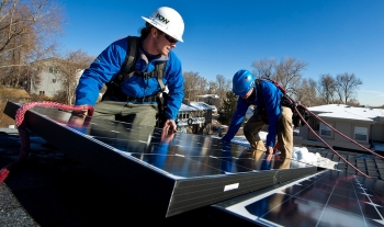 Kyle Travis, left and Jon Jackson, with Lighthouse Solar, install microcrystalline PV modules on top of Kevin Donovan's town home. | Credit: Dennis Schroeder. Kyle Travis, left and Jon Jackson, with Lighthouse Solar, install microcrystalline PV modules on top of Kevin Donovan's town home. | Credit: Dennis Schroeder.