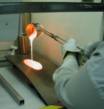 A glass scientist works with molten glass. A glass scientist works with molten glass.