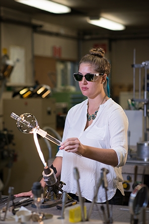 Babbitt demonstrates her scientific glass technology skills. Babbitt demonstrates her scientific glass technology skills.