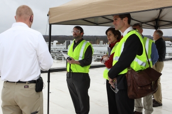 On the roof of the Cummins plant, tour participants take a peek at a new 2 MW solar panel installation. From left to right: Dennis Phillips, the Jamestown Post Journal, Maria Vargas, DOE, Andre de Fontaine, DOE, Mike Abbate, Cummins.| Photo courtesy of Cummins Inc. On the roof of the Cummins plant, tour participants take a peek at a new 2 MW solar panel installation. From left to right: Dennis Phillips, the Jamestown Post Journal, Maria Vargas, DOE, Andre de Fontaine, DOE, Mike Abbate, Cummins.| Photo courtesy of Cummins Inc.