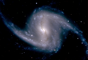 Zoomed-in image from the Dark Energy Camera of the barred spiral galaxy NGC 1365, in the Fornax cluster of galaxies, which lies about 60 million light years from Earth -- in other words, far, far away. | Photo courtesy of the Dark Energy Survey Collaboration. Zoomed-in image from the Dark Energy Camera of the barred spiral galaxy NGC 1365, in the Fornax cluster of galaxies, which lies about 60 million light years from Earth -- in other words, far, far away. | Photo courtesy of the Dark Energy Survey Collaboration.