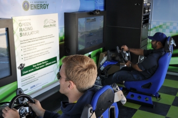 Race fans drive the Green Racing Simulator at the Rolex 24 at Daytona. The simulator was developed at Argonne National Laboratory and is now operated by Oak Ridge National Laboratory. | Photo by Natalie Committee, Energy Department Race fans drive the Green Racing Simulator at the Rolex 24 at Daytona. The simulator was developed at Argonne National Laboratory and is now operated by Oak Ridge National Laboratory. | Photo by Natalie Committee, Energy Department
