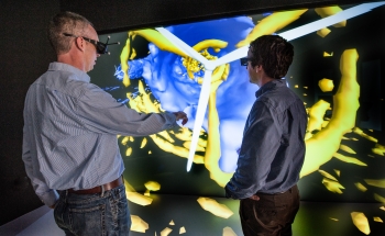 NREL Senior Engineering Project Manager, Pat Moriarty, left and NREL Senior Engineer , Paul Fleming, review velocity (blue) and turbulence (yellow) in a simulation of the Lillgrund Wind Farm in Denmark, in the Visualization Lab in the ESIF at the National Renewable Energy Lab. The researchers have written Open Source software that simulates wind farm conditions. NREL Senior Engineering Project Manager, Pat Moriarty, left and NREL Senior Engineer , Paul Fleming, review velocity (blue) and turbulence (yellow) in a simulation of the Lillgrund Wind Farm in Denmark, in the Visualization Lab in the ESIF at the National Renewable Energy Lab. The researchers have written Open Source software that simulates wind farm conditions.