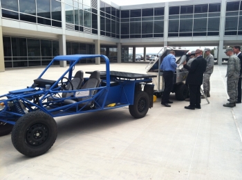 Air Force Academy staff and cadets showing FEMP directors the technical highlights of a trailer designed to collect and store solar and wind energy to power an electric expeditionary vehicle indefinitely. Photo Courtesy | Oak Ridge National Laboratory Air Force Academy staff and cadets showing FEMP directors the technical highlights of a trailer designed to collect and store solar and wind energy to power an electric expeditionary vehicle indefinitely. Photo Courtesy | Oak Ridge National Laboratory