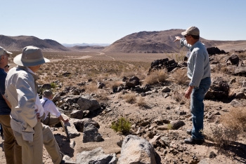JASON study members take in the landscape at Sugarloaf, an 86,000-year-old rhyolite dome in eastern California, and among the youngest dated volcanoes in the field. Andy Sabin (right), director of the Navy Geothermal Program Office, led the field trip to the Coso geothermal field, where the Navy generates 270 megawatts of geothermal power. | Photo courtesy of Michael Gregg JASON study members take in the landscape at Sugarloaf, an 86,000-year-old rhyolite dome in eastern California, and among the youngest dated volcanoes in the field. Andy Sabin (right), director of the Navy Geothermal Program Office, led the field trip to the Coso geothermal field, where the Navy generates 270 megawatts of geothermal power. | Photo courtesy of Michael Gregg
