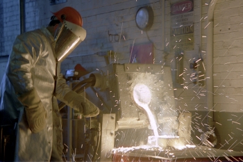 A worker uses an induction furnace to pour hot metal into an evaporative pattern mold. | Photo courtesy of the National Energy Technology Laboratory. A worker uses an induction furnace to pour hot metal into an evaporative pattern mold. | Photo courtesy of the National Energy Technology Laboratory.