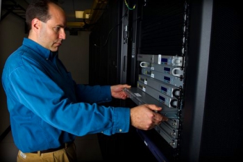 National Renewable Energy Laboratory (NREL) Technician Mic Stremel works with a blade server in the green data center at the Research Support Facility.
| Image courtesy of NREL, Dennis Schroeder. National Renewable Energy Laboratory (NREL) Technician Mic Stremel works with a blade server in the green data center at the Research Support Facility.
| Image courtesy of NREL, Dennis Schroeder.
