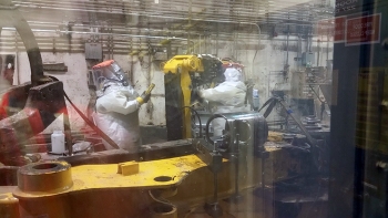 Technicians install one of two new robotic arms in the Treatment Facility boxlines. Technicians install one of two new robotic arms in the Treatment Facility boxlines.