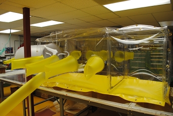 Containment Fabrication Facility workers created a waste repackaging glove bag used for processing radioactive materials. Containment Fabrication Facility workers created a waste repackaging glove bag used for processing radioactive materials.