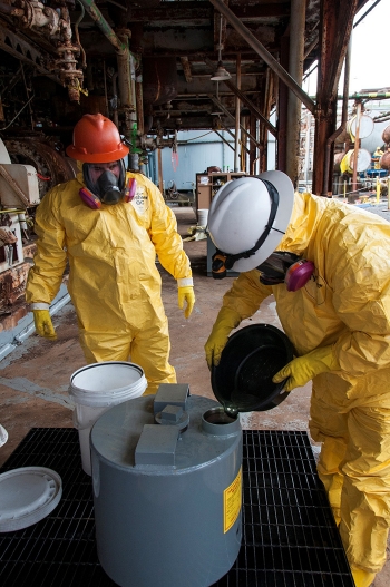 Workers pour mercury from COLEX equipment into a container designed to hold 1,000 pounds of the element. Workers pour mercury from COLEX equipment into a container designed to hold 1,000 pounds of the element.