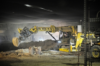 Workers exhume buried transuranic waste from Pit 9. Workers exhume buried transuranic waste from Pit 9.