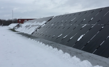 At the Regional Test Center in Williston, Vermont, researchers are examining how framed (in the background) and frameless (in the foreground) solar photovoltaic modules handle snowy conditions. | Photo Courtesy: Sandia National Laboratories At the Regional Test Center in Williston, Vermont, researchers are examining how framed (in the background) and frameless (in the foreground) solar photovoltaic modules handle snowy conditions. | Photo Courtesy: Sandia National Laboratories