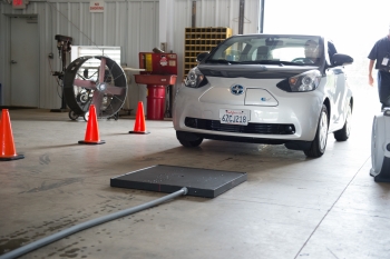 Researchers from Oak Ridge National Laboratory test a wireless charger on the fully-electric Toyota Scion iQ at a demonstration site. | Photo courtesy of Oak Ridge National Laboratory Researchers from Oak Ridge National Laboratory test a wireless charger on the fully-electric Toyota Scion iQ at a demonstration site. | Photo courtesy of Oak Ridge National Laboratory