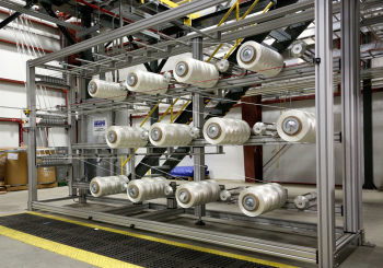 The facility will produce up to 25 tons of carbon fiber a year -- enough to satisfy R&D requirements while enabling large-scale manufacturing of carbon fiber products. Pictured here is the first stage in the carbon fiber production process, where spooled precursor material is fed into the conversion line. Precursor material may be spun into rolls or blown into a mat form before being conveyed through the stabilization, carbonization, and surface treatment steps of the process. | Photo courtesy of Oak Ridge National Laboratory. The facility will produce up to 25 tons of carbon fiber a year -- enough to satisfy R&D requirements while enabling large-scale manufacturing of carbon fiber products. Pictured here is the first stage in the carbon fiber production process, where spooled precursor material is fed into the conversion line. Precursor material may be spun into rolls or blown into a mat form before being conveyed through the stabilization, carbonization, and surface treatment steps of the process. | Photo courtesy of Oak Ridge National Laboratory.