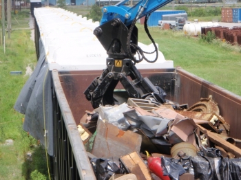 A crane loads a highâside railcar for transport to a commercial waste disposal facility after the material was reduced in size. A crane loads a highâside railcar for transport to a commercial waste disposal facility after the material was reduced in size.