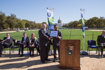 William Davis, the director of the National Alternative Fuels Training Consortium that organizes Odyssey Day, recognizes the Department of Energy's contributions towards promoting alternative fuel vehicles with DOE's Deputy Assistant Secretary for Transportation Reuben Sarkar. William Davis, the director of the National Alternative Fuels Training Consortium that organizes Odyssey Day, recognizes the Department of Energy's contributions towards promoting alternative fuel vehicles with DOE's Deputy Assistant Secretary for Transportation Reuben Sarkar.