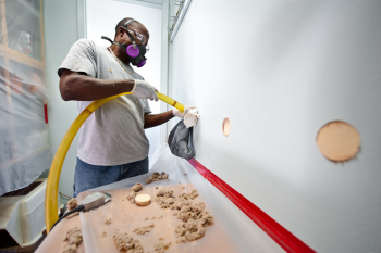 William Stewart, with Veterans Green Jobs, blows cellulose insulation in the interior walls of a Lakewood, Colorado, home. This home is part of the Energy Department's Weatherization Assistance Program that supports energy efficiency upgrades to low-income homes in Denver. | Photo courtesy of Dennis Schroeder, NREL. William Stewart, with Veterans Green Jobs, blows cellulose insulation in the interior walls of a Lakewood, Colorado, home. This home is part of the Energy Department's Weatherization Assistance Program that supports energy efficiency upgrades to low-income homes in Denver. | Photo courtesy of Dennis Schroeder, NREL.