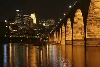 The City of Minneapolis, or the âCity of Lakesâ, lies on both banks of the Mississippi River in Minnesota. Once the flour milling capital of the world, the larger of the Twin Cities is now a thriving Midwestern economic hub. â Photo courtesy of Meet Minneapolis. The City of Minneapolis, or the âCity of Lakesâ, lies on both banks of the Mississippi River in Minnesota. Once the flour milling capital of the world, the larger of the Twin Cities is now a thriving Midwestern economic hub. â Photo courtesy of Meet Minneapolis.